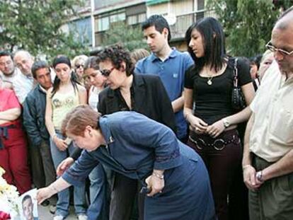 La madre de Manuel G. C. deja una foto en el banco donde murió su hijo.