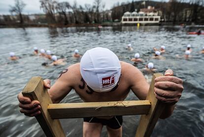 Un participante se sumerge en el río Vltava durante la tradicional prueba de natación navideña en Praga (República Checa).