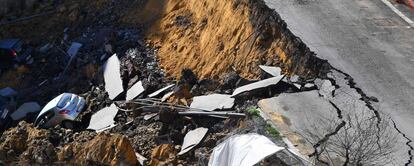 The picture taken on February 15, 2018 in the street of Balduina's district in Rome shows a huge sinkhole that opened up the day before in Rome, swallowing six cars. No casualties were reported. About 22 families were evacuated by firefighters following the collapse. The cause of the sinkhole is still under investigation. / AFP PHOTO / TIZIANA FABI