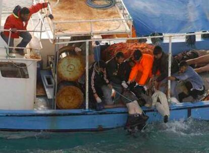 Miembros de los equipos de rescate turcos recuperan algunos de los cadáveres de las víctimas del naufragio en el mar Egeo.