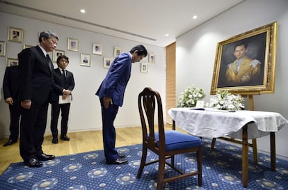 El primer ministro japonés, Shinzo Abe, hace una reverencia ante el retrato del rey Bhumibol Adulyadej de Tailandia tras firmar en el libro de condolencias instalado en la Embajada de Tailandia en Tokio (Japón).