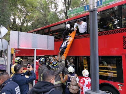 Bomberos bajan a un pasajero herido tras el impacto entre un autobús y un Metrobús, en Paseo de la Reforma, en Ciudad de México.