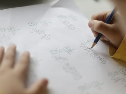 Un niño realiza operaciones matemáticas en casa.