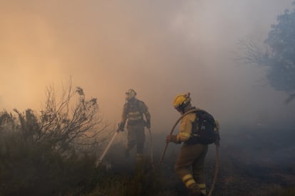 Dos integrantes de la 'Brigada Hormiga' apagan uno de los focos del incendio en Pentes, Ourense, este miércoles.