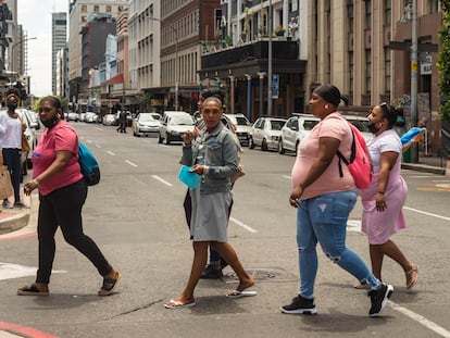 Un grupo de mujeres sin mascarilla cruza Long Street en Ciudad del Cabo, Sudáfrica, en diciembre de 2020, al comienzo de la segunda ola de covid-19 en este país.