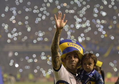 Carlos Tevez saluda a los aficionados de Boca Junior mientras sostiene a su hijo después de ganar el Campeonato de fútbol de la división primera de Argentina en el estadio "La Bombonera" de Buenos Aires.