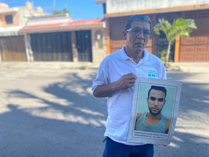 Santiago Pérez sostiene un cartel con la imagen de su hijo.