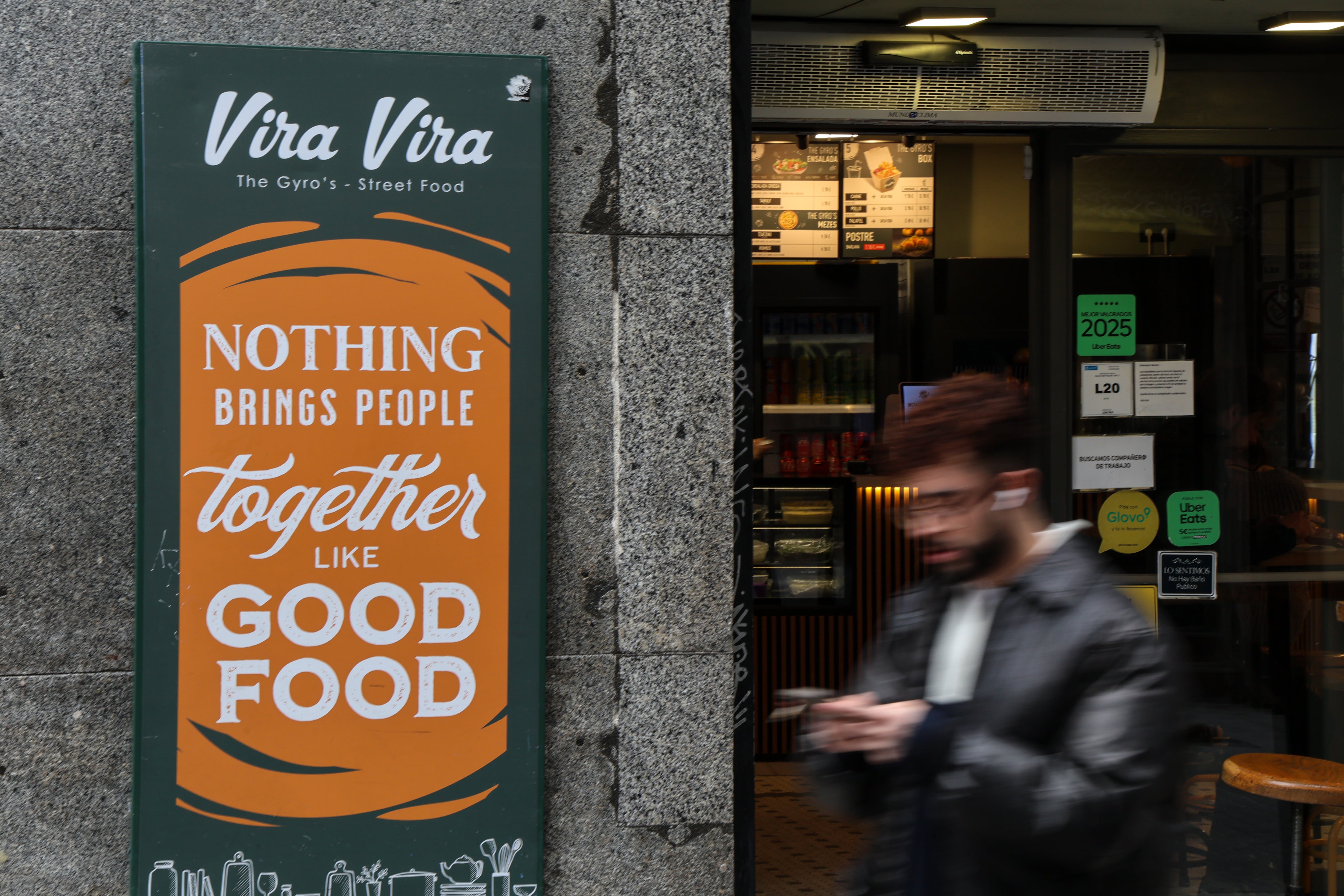 Un turista frente a una cadena de restaurantes griegos en el barrio de Malasaña, Madrid, el 30 de enero de 2026. 