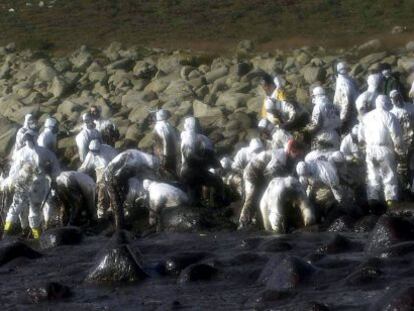 Voluntarios limpian chapapote del 'Prestige' en los alrededores del cabo Touriñán (A Coruña).