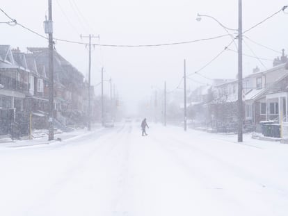 Un hombre cruza la calle durante la tormenta de nieve en Ontario, Canadá.