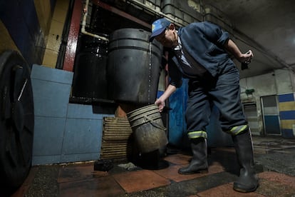 Un trabajador llena una cubeta con agua recolectada en el barrio Marsella, en Bogotá, durante el racionamiento impuesto por la alcaldía en abril de 2024.