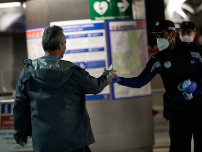 Agentes de la Policía Municipal de Madrid reparten mascarillas a los viajeros en la estación de metro de Sol.