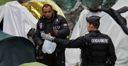 Un agente francés hace un gesto a un migrante durante el desalojo de un campo en el centro de París, el pasado 4 de junio.