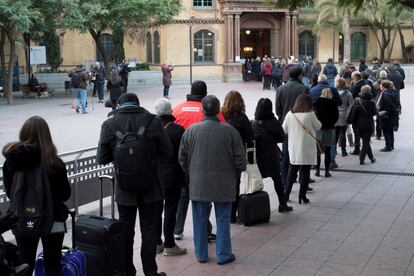 Nombroses persones esperen per votar a les meses electorals de l'Escola Industrial de Barcelona durant la primera hora de votació.