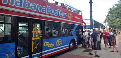 Turistas abordan un autob&uacute;s tur&iacute;stico en una calle de La Habana (Cuba).