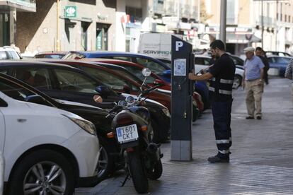 Un operario arregla un parquimetro en la Calle Magallanes. La prohibición de estacionamiento a no residentes es la antesala del llamado escenario 3, que impediría entrar al 50% de los vehículos en la zona SER.