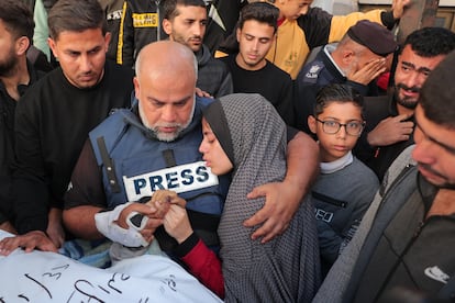 El periodista de Al Jazeera Wael al Dahdouh coge la mano de su hijo Hamza, también informador y fallecido en un ataque israelí, mientras abraza a una de sus hijas el 7 de enero.