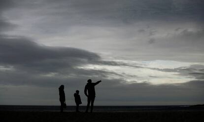 Una familia caminaba por la playa de Riazor, en A Coruña.