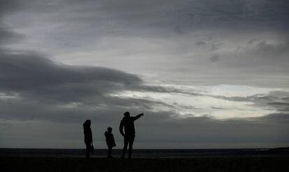 Una familia caminaba por la playa de Riazor, en A Coruña. 