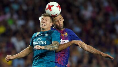 Busquets disputa el balón con Kroos.