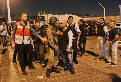 Un policía turco se enfrenta a un soldado que participó en el intento de golpe de Estado tras ser retenido y entregado por civiles en la plaza Taksim de Estambul, el 16 de julio de 2016 .