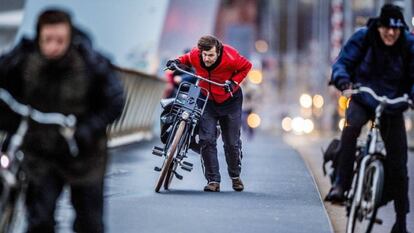 Tres ciclistas luchan contra las rachas de viento este jueves en Rotterdam. 