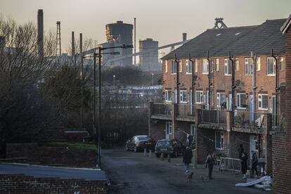Una fila de casas de clase obrera en la localidad industrial de Redcar (Middlesbrough), que solía vivir de la producción de hierro y acero. Al fondo, una de las fábricas de acero que cerró hace años dejando a miles de personas desempleadas.