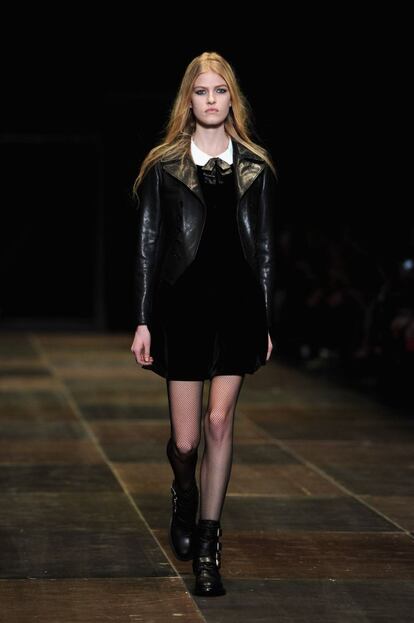 M&iacute;nimos vestidos de &lsquo;baby-doll&rsquo; con medias de rejilla, botas moteras, camisas de cuadros y cazadoras de cuero componen el grueso de la oferta de Saint Laurent para oto&ntilde;o/invierno 2013. Un men&uacute; radicalmente alejado de la oferta habitual de la firma antes de la llegada de Slimane y, por lo tanto, llamado a suscitar controversia. 