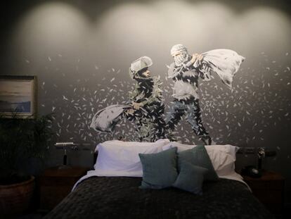 Banksy ha decorado las salas del hotel 'The Walled Off' que este viernes abrió sus puertas para los medios en Belén, en Cisjordania, y cuyas habitaciones tienen vistas al muro de separación construido por Israel. En la imagen, un grafiti del artista Banksy muestra a un soldado israelí y a un joven palestino enmascarado durante una pelea de almohadas.