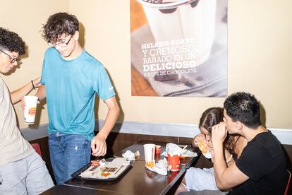 Dylan, Juan Pedro, Laura y Jonathan cenan unas hamburguesas en el centro comercial.