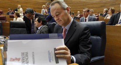 Alberto Fabra consulta unos papeles en las Cortes Valencianas.