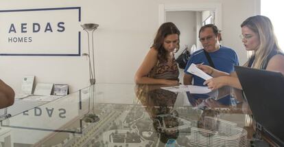 Unos potenciales compradores reciben información de una promoción de vivienda nueva de Aedas en Sevilla.