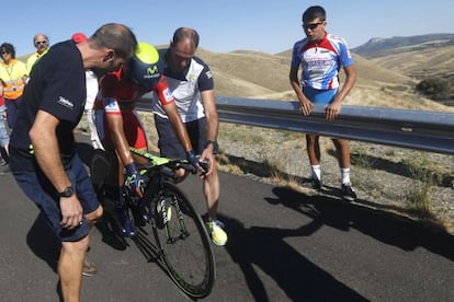 El colombiano Nairo Quintana es ayudado tras su ca&iacute;da.