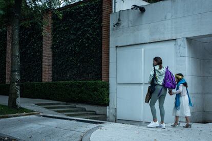 Una mujer camina de la mano de una menor al exterior del la escuela privada Humanitree, en Ciudad de México.