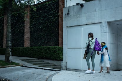 Una mujer camina de la mano de una menor al exterior del la escuela privada Humanitree, en Ciudad de México.