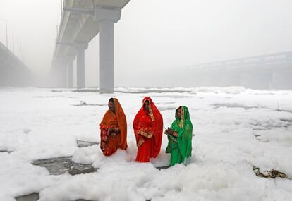 Varias mujeres hindúes adoran al dios Sol en las aguas contaminadas del río Yamuna durante el festival religioso de Chatth Puja en Nueva Delhi.