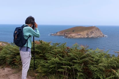 Un senderista retrata la isla Coelleira desde la costa de O Vicedo.