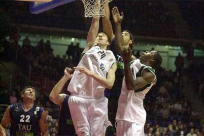 Scola intenta palmear frente a la oposición de dos jugadores del Unicaja.