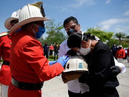 Bomberos de Guayaquil entregan a la hija de Luis Paez el casco de su padre, fallecido de covid-19, al igual que su madre, en esta ciudad ecuatoriana.