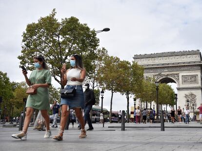 Personas con mascarillas, paseando por el distrito de los Campos Elíseos, en París, Francia.