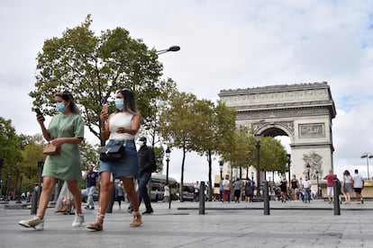 Personas con mascarillas, paseando por el distrito de los Campos Elíseos, en París, Francia.