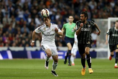 Chicharito se lleva un balón en presencia de Angeleri durante el encuentro entre el Real Madrid y el Málaga.