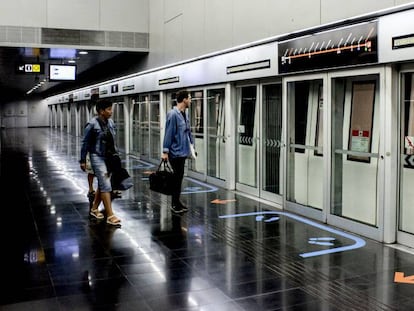 Uns passatgers pugen al metro que recorre la línia 9.