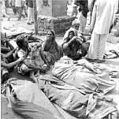 Familiares de víctimas del terremoto, junto a los cadáveres en la localidad de Killari, en el Estado de Maharashtra.