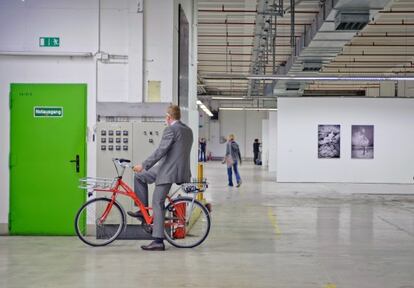 Bertram Schultze, desarrollador del proyecto MIB/ Auf AEG, subido a una bicicleta en el Hall 15.