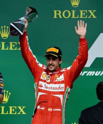 Second-place finisher Ferrari driver Fernando Alonso holds the trophy on the podium after the Canadian Grand Prix. 