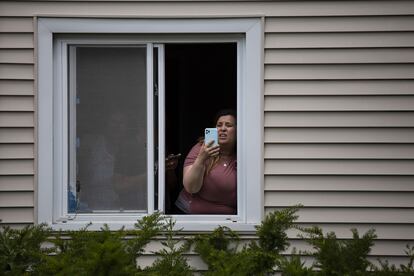Una residente graba con su teléfono el operativo policial posterior al tiroteo en el desfile, en Highland Park, Illinois.