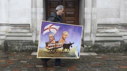 O artista Kaya Mar carrega uma de suas obras, inspirada no 'Brexit'.