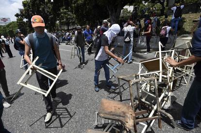 Activistas de la oposición forman una barricada durante la protesta contra el gobierno de Nicolás Maduro, en Caracas.