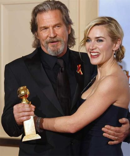 Jeff Bridges, ganador del premio al Mejor Actor, posa con Kate Winslet, de cuyas manos recibio el galardón